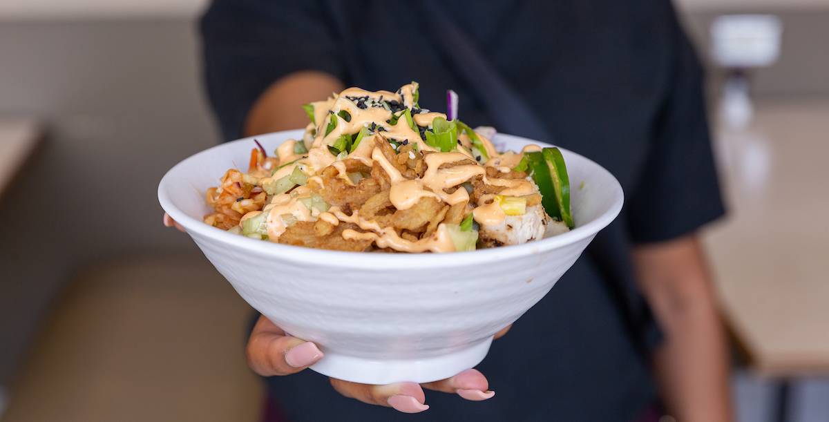 Employee holding Poke Bowl