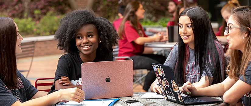 a group of students studying at a table outdoors