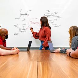 Person in front of a whiteboard discussing marketing strategy