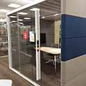 enclosed study space with transparent walls, table and chairs