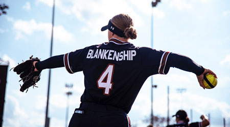 Member's of the softball team take warmup tosses before a game