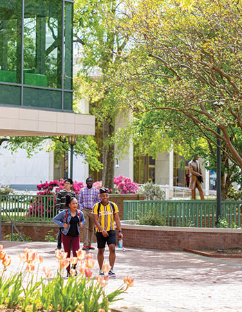 Students walking through an outdoor patio on a beautiful spring day.