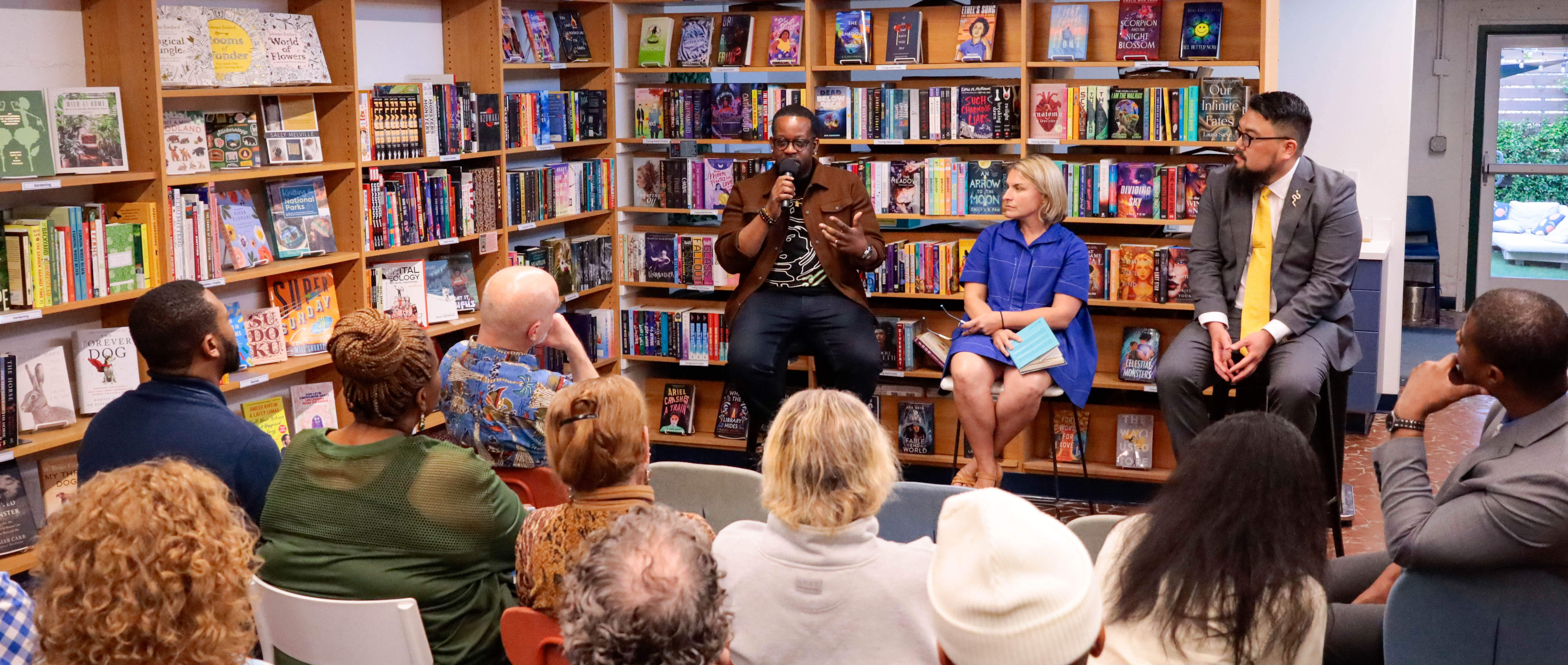 Photo of Jabari Evans, Leah McClimans, and Seulghee Lee speaking to a crowd for the book launch of their work