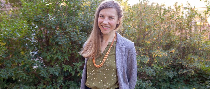 Woman smiling with flower shirt on  on outside 