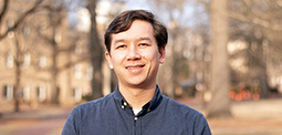 A man standing on horseshoe smiling. 