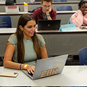 student in class on laptop looking up something