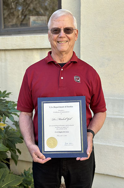 Mitch Yell holding a commendation from the Dept of Justice