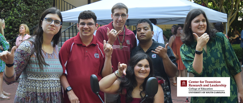 group of students giving the "Spurs Up" sign with thumb and pinky outstretched.