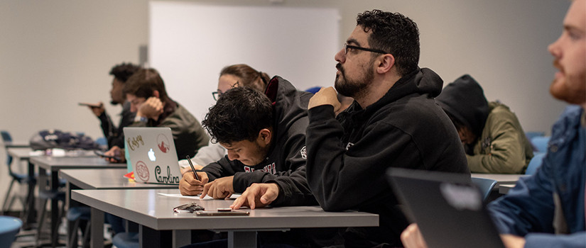 row of students take notes in class