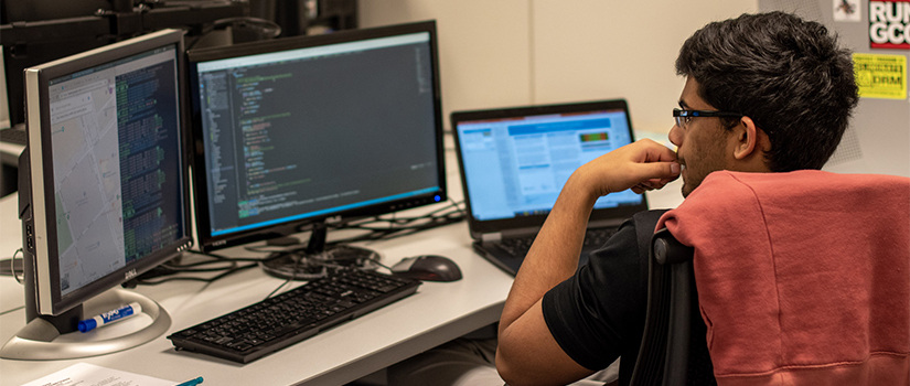 two students look at a computer screen in a lab