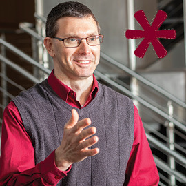 headshot of travis knight with garnet star icon