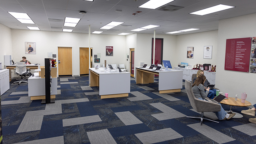 The Gamecock iHub located on the 7th floor of Close-Hipp. Laptops and computer displayed on tabletops. Students sit around a table.