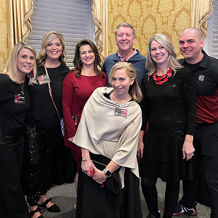 Seven members of the HRSM Alumni Society board pose for a photo inside the McCutchen House.