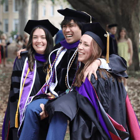 graduates picking up another smiling