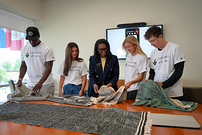 Dr. Deb Hazzard and Moore School students looking at fabric from Zambia