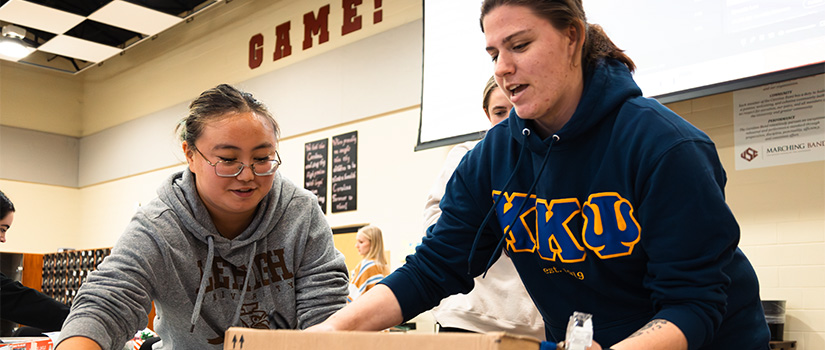 two student wrapping a box