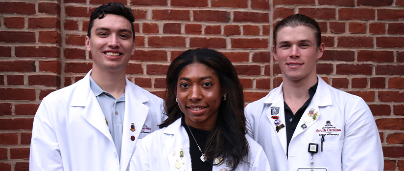 Three students in white coats