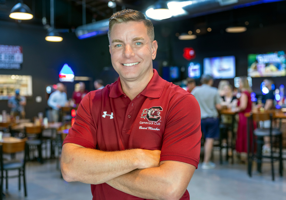 James Wolf stands in a restaurant wearing Gamecock club shirt