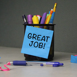 Cup full of pens with post-it note on it that reads 