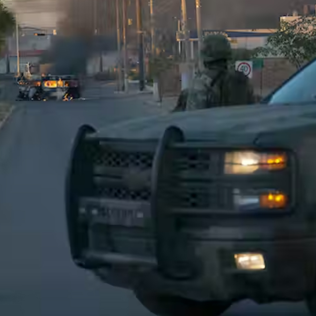 A police officer watches a car on fire