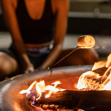 Marshmallow being roasted over a fire pit.