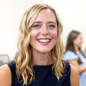 Christina Cox smiles in front of a group of pharmacy students