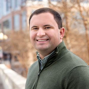 Ross Lordo smiles in front of Greenville buildings