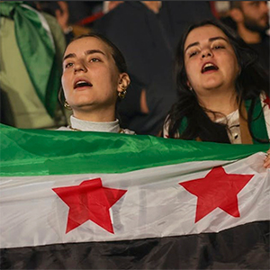 Two women holding Syrian flag