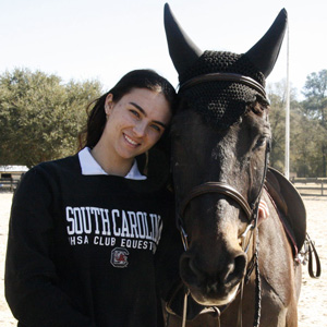 A girl smiles with her horse.