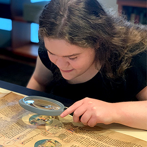 Hannah Martin looking at a document through a microscope.