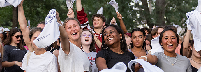 A group of girls swinging rally towels and smiling at First Night Carolina.