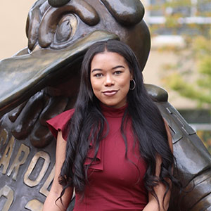 Amber Devine sits with Cocky statue